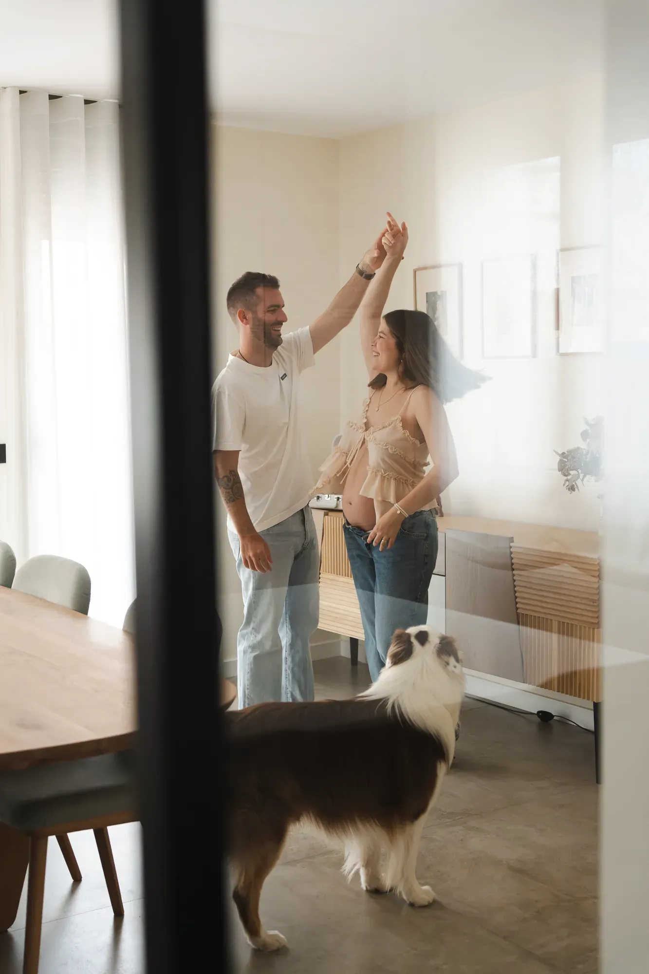 Pareja bailando en el salón mientras su perro les mira